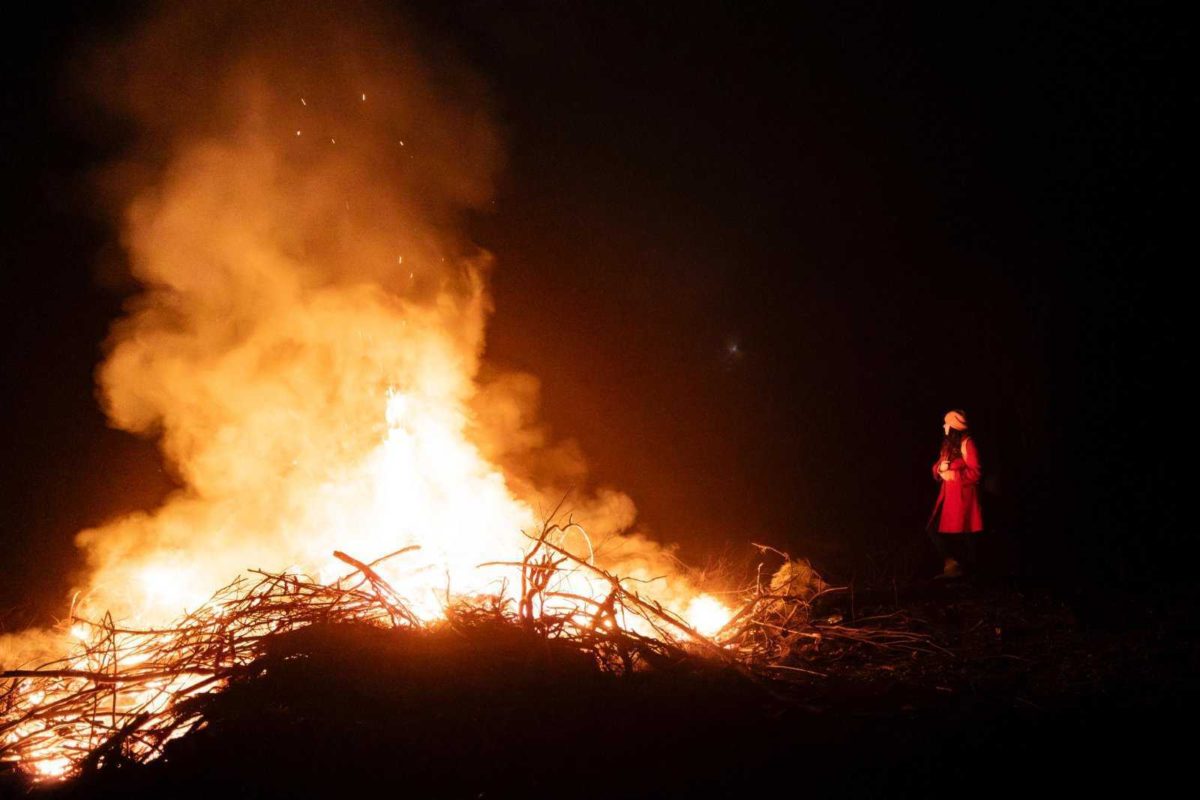 голяма огнена клада и малка фигура до нея