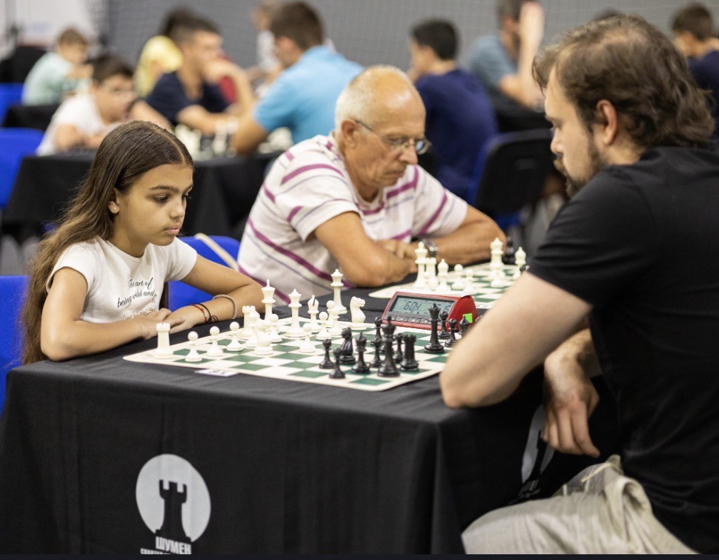 състезание по шахмат, проведено между дете и възрастен мъж